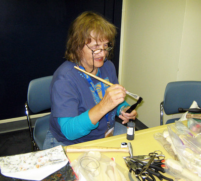 Meta painting her dolls